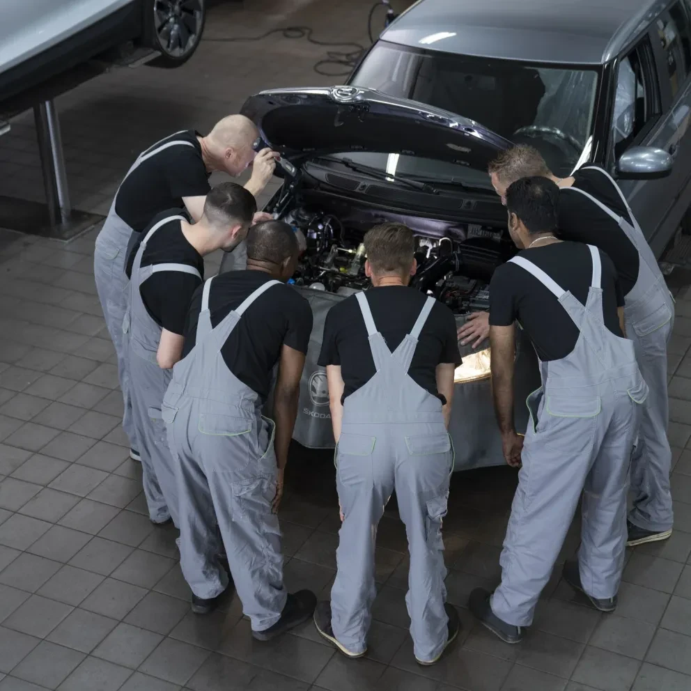 Skoda monteurs rondom motor in werkplaats