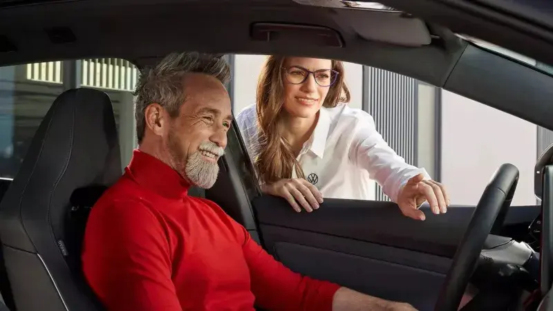 Vrouw wijst man multimediascherm aan in een auto